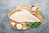 Fillet of sea white cod fish on parchment with fresh raw champignons before cooking. Zero waste kitchen. Healthy food seafood. Top view, space.