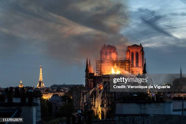 Flames and smoke are seen billowing from the roof at Notre-Dame Cathedral on April 15, 2019 in Paris, France. A fire broke out on Monday afternoon...