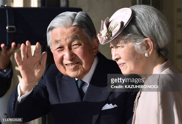 Japan's Emperor Akihito and Empress Michiko wave to well-wishers before leaving Ujiyamada Station after their visiting Ise Jingu shrine in Ise in the...