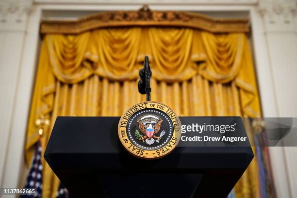 Podium with the presidential seal stands before the start of an event recognizing the Wounded Warrior Project Soldier Ride in the East Room of the...