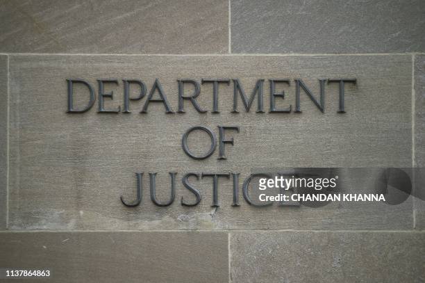 Department of Justice" sign is seen on the wall of the US Department of Justice building in Washington, DC on April 18, 2019. - The final report from...