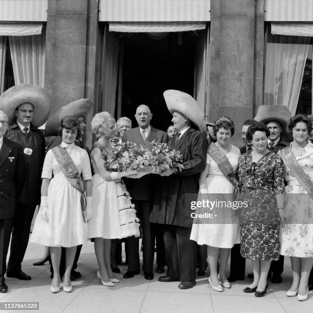 President Charles de Gaulle and his wife Yvonne de Gaulle pose alongside the "Queen of Halles" accompanied by "Forts des Halles" who came to offer...