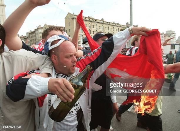 Des supporters anglais brûlent le drapeau national tunisien, le 14 juin, sur le Vieux Port de Marseille, à la suite des incidents qui ont opposés les...