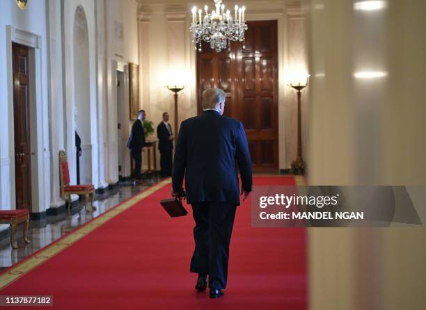 President Donald Trump departs with a trophy after speaking at an event honoring the Wounded Warrior Project Soldier Ride in the East Room of the...