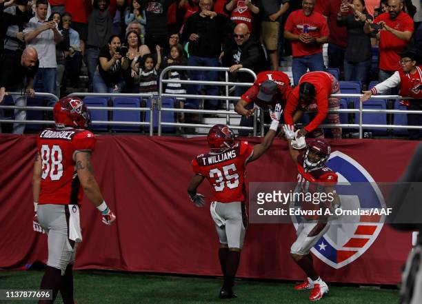 Trey Williams of the San Antonio Commanders celebrates his touchdown with fans and teammate Greg Ward Jr. #84 against the Salt Lake Stallions at...