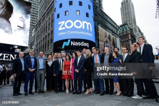 Zoom founder Eric Yuan poses with members of his company in front of the Nasdaq building as the screen shows the logo of the video-conferencing...