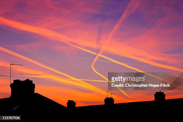 rooftop sunset - sunset with jet contrails stock pictures, royalty-free photos & images