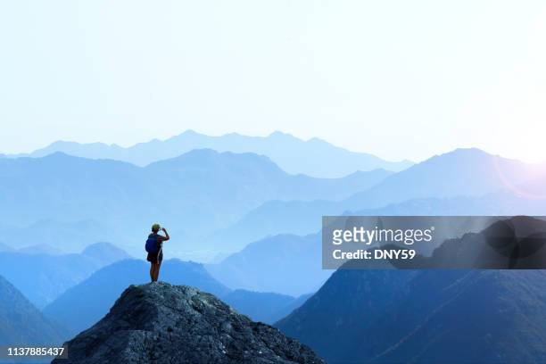 mujer excursionista tomando la imagen de sunset - mujer de espaldas en paisaje fotografías e imágenes de stock