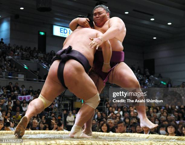Myogiryu pushes komusubi Mitakeumi out of the ring to win on day twelve of the Grand Sumo Spring Tournament at Edion Arena Osaka on March 21, 2019 in...