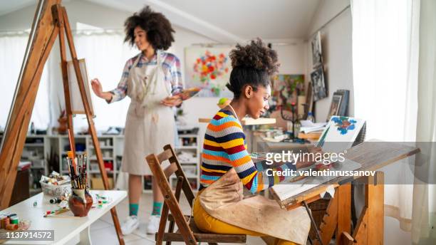 afro female fine artists drawing in studio - artist imagens e fotografias de stock