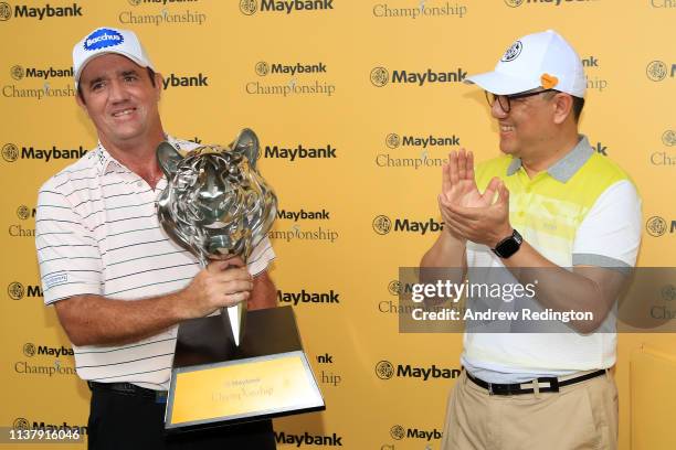 Scott Hend of Australia is given the trophy after he wins the play off match against Nacho Elvira of Spain during Day Four of the Maybank...