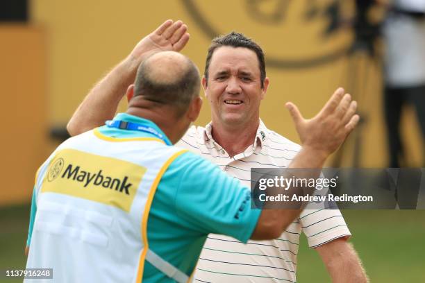 Scott Hend of Australia celebrates with his caddie after his putt after he wins the play off match against Nacho Elvira of Spain during Day Four of...