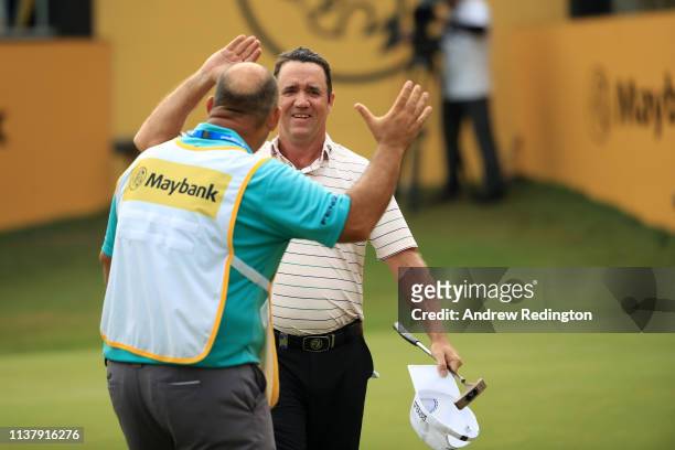 Scott Hend of Australia celebrates with his caddie after his putt after he wins the play off match against Nacho Elvira of Spain during Day Four of...