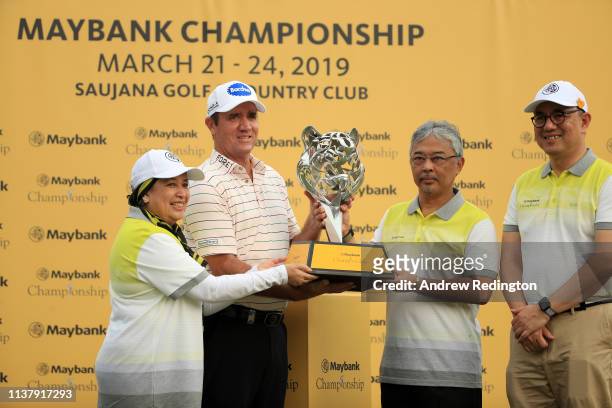 Scott Hend of Australia is given the trophy by Abdullah of Pahang, King of Malaysia after he wins the play off match against Nacho Elvira of Spain...