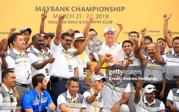 Scott Hend of Australia holds the trophy with the volunteers after he wins the play off match against Nacho Elvira of Spain during Day Four of the...