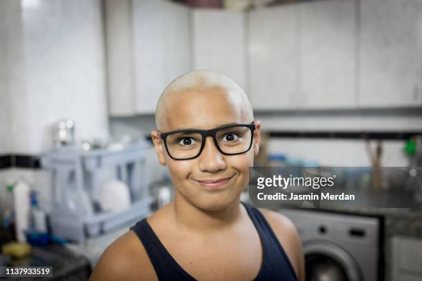 sick bald boy in kitchen smiling - kids cancer smile stock pictures, royalty-free photos & images
