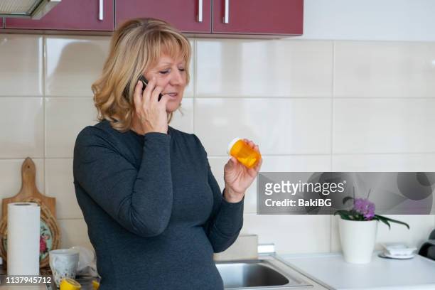senior  diabetic woman talking with her doctor  by phone from home - diabetes pills stock pictures, royalty-free photos & images