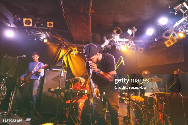 multi-ethnic music performance group performing on stage - singer drummer stock pictures, royalty-free photos & images