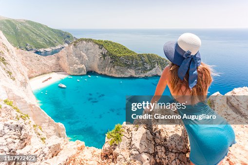 Young woman with a straw hat admiring the Shipwreck Beach, Zakynthos, Ionian Islands, Greece, Europe Young woman with a straw hat admiring the Shipwreck Beach, Zakynthos, Ionian Islands, Greece, Europe