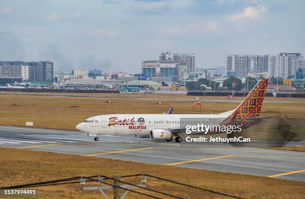 boeing 737-800 airplane of batik air malaysia taxiing on runway of tan son nhat airport (sgn) in saigon - malaysia batik stock pictures, royalty-free photos & images