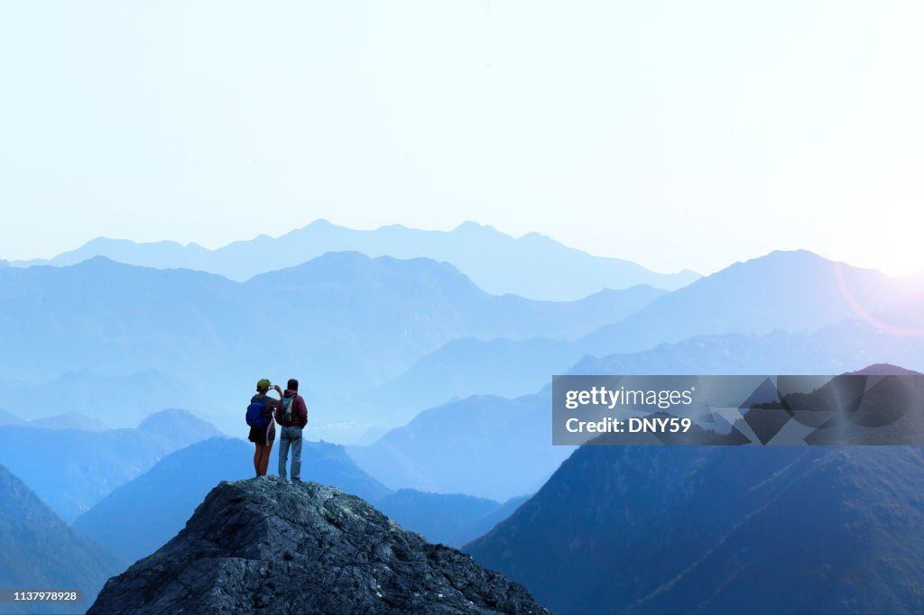 Hiker femenino y masculino tomando la imagen de Sunset