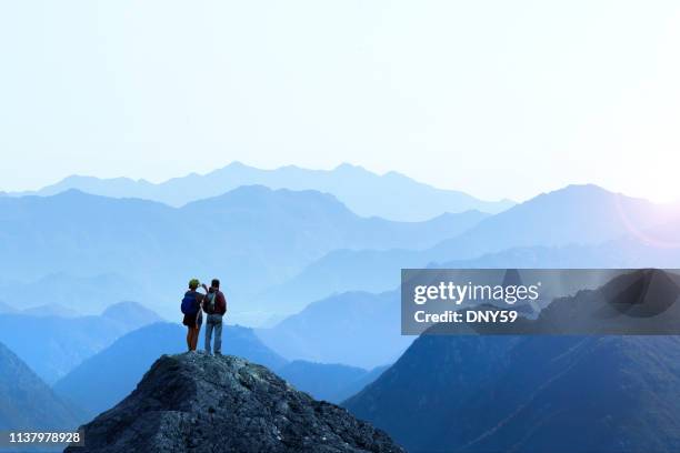 female and male hiker taking picture of sunset - hike mountain stock pictures, royalty-free photos & images