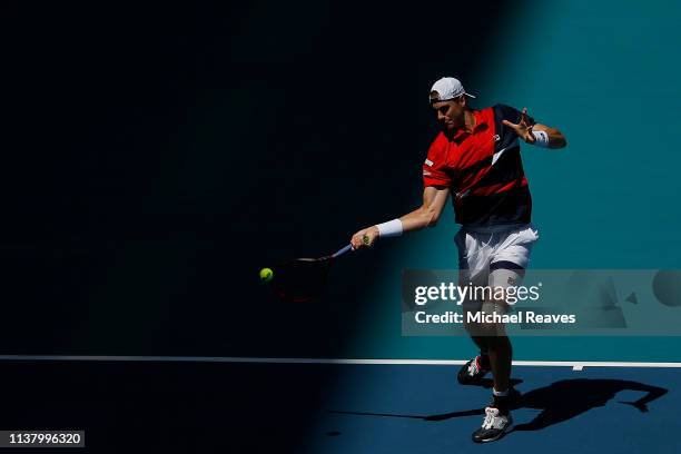 John Isner of the United States returns a shot to Albert Ramos Vinolas of Spain during Day 7 of the Miami Open Presented by Itau at Hard Rock Stadium...