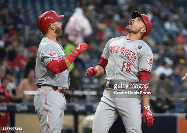 Joey Votto of the Cincinnati Reds celebrates with Eugenio Suarez after hitting a solo home run during the first inning of a baseball game against the...