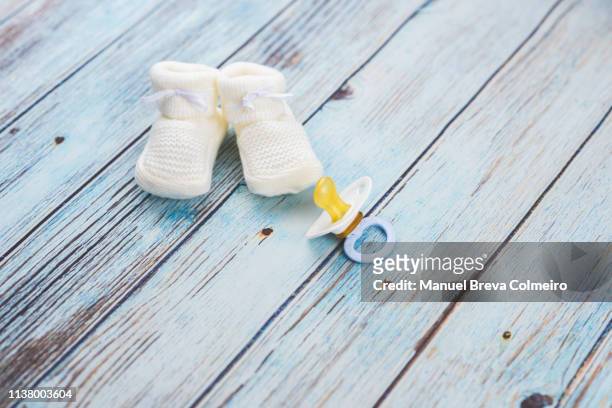 baby booties on a wooden table - 赤ちゃんの靴 ストックフォトと画像