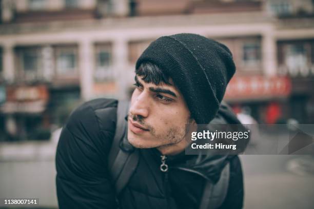 jonge toerist zittend op straat - knit hat stockfoto's en -beelden