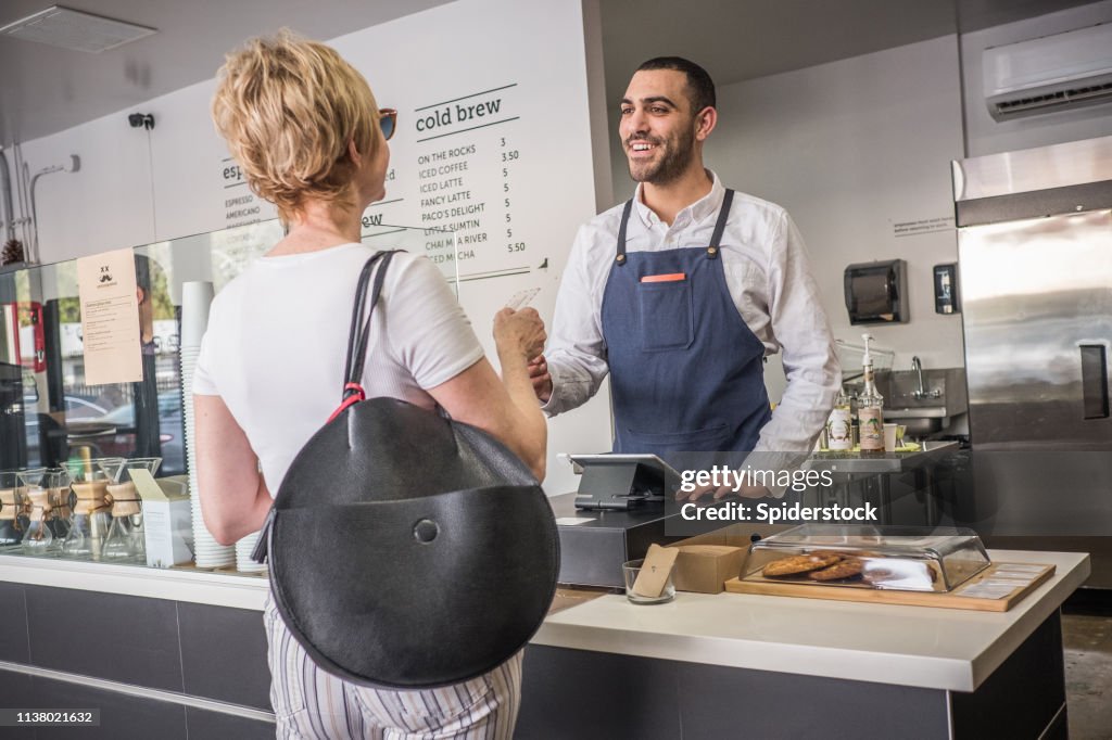 Weiblicher Kunde kauft Kaffee in einem Coffee Shop
