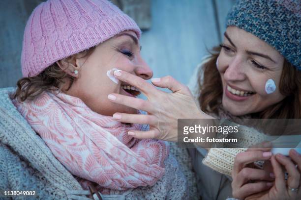skin care during winter vacation - mature women skincare stock pictures, royalty-free photos & images