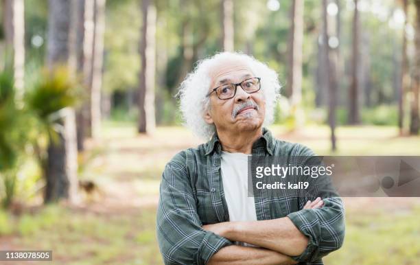 homem latino-americano sênior com cabelo branco e eyeglasses - teimoso - fotografias e filmes do acervo
