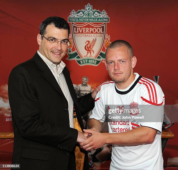 Jay Spearing of Liverpool shakes hands with Director of Football Damien Comolli after extending his contract on May 6, 2011 in Liverpool, England.