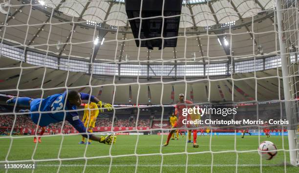 Goalkeeper, Jean-Beaunel Petit-Homme, of French Guiana dives as Atiba Hutchinson of Canada watches Canada's fourth goal cross the goal line during...