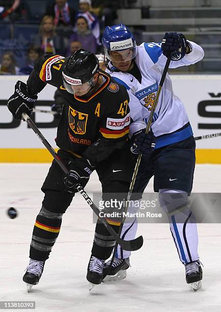 Christoph Ullmann of Germany and Jarkko Immonen of Finland battle for the puck during the IIHF World Championship qualification match between Germany...