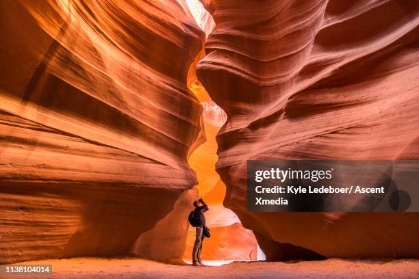 view down canyon walls to photographer - antelope canyon stock pictures, royalty-free photos & images