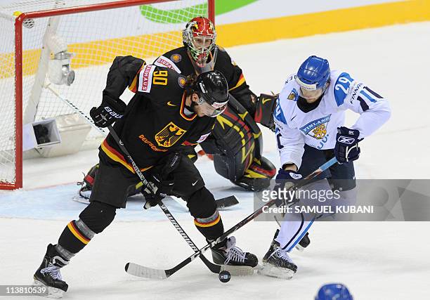 Constantin Braun of Germany fights for the puck with Petteri Nokelainen of Finland during the IIHF Ice Hockey World Championship Qualification Round...