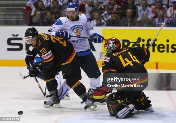 Robert Dietrich of Germany and Janne Lahti of Finland battle for the puck during the IIHF World Championship qualification match between Germany and...