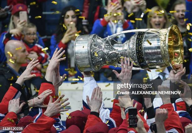 Moscow players hold the trophy as they celebrate their victory over Avangard Omsk after the Gagarin Cup 2019 final series game of the Russian...