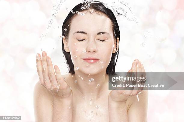 young woman washing her face with cold water - gesichtsreinigung stock-fotos und bilder