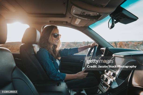 single woman driving a car - driving enjoyment stock pictures, royalty-free photos & images