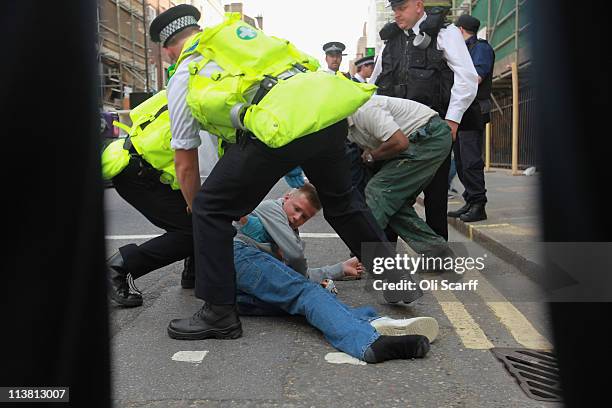 Man is assisted by police medics during a protest against the killing of Osama bin Laden outside the US embassy in Mayfair on May 6, 2011 in London,...