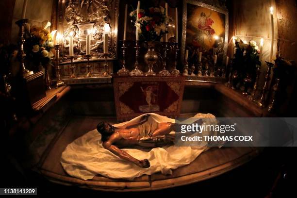 The statue of Jesus rests on the marble inside the Tomb of Christ after a reenactment of the Funeral of Jesus in the Church of the Holy Sepulchre...