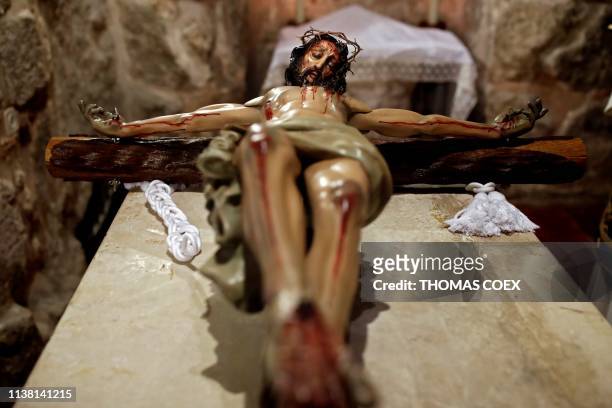 Statue of Jesus crucified on the Cross is seen before a reenactment of the Funeral of Jesus at the Church of the Holy Sepulchre during the Good...