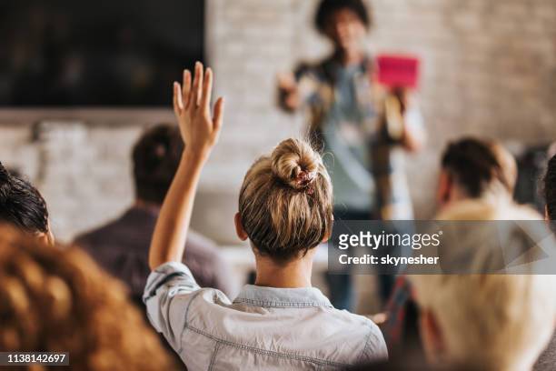 back view of a woman wants to ask a question on a seminar. - casual clothing stock pictures, royalty-free photos & images