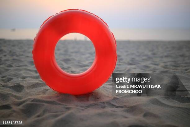 red swim ring on the beach. - float imagens e fotografias de stock