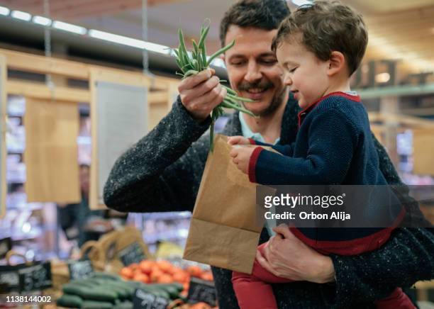 boy in choosing veggies at the market - mini grocery store stock pictures, royalty-free photos & images