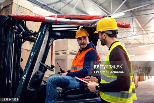 workers in warehouse with forklift - forklift truck stock pictures, royalty-free photos & images