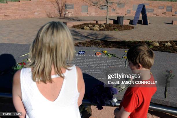 Ann Largent with her son Ryan, of Lakewood, Colorado, visit the Columbine Memorial at Clement Park in Littleton, Colorado, before a community vigil...